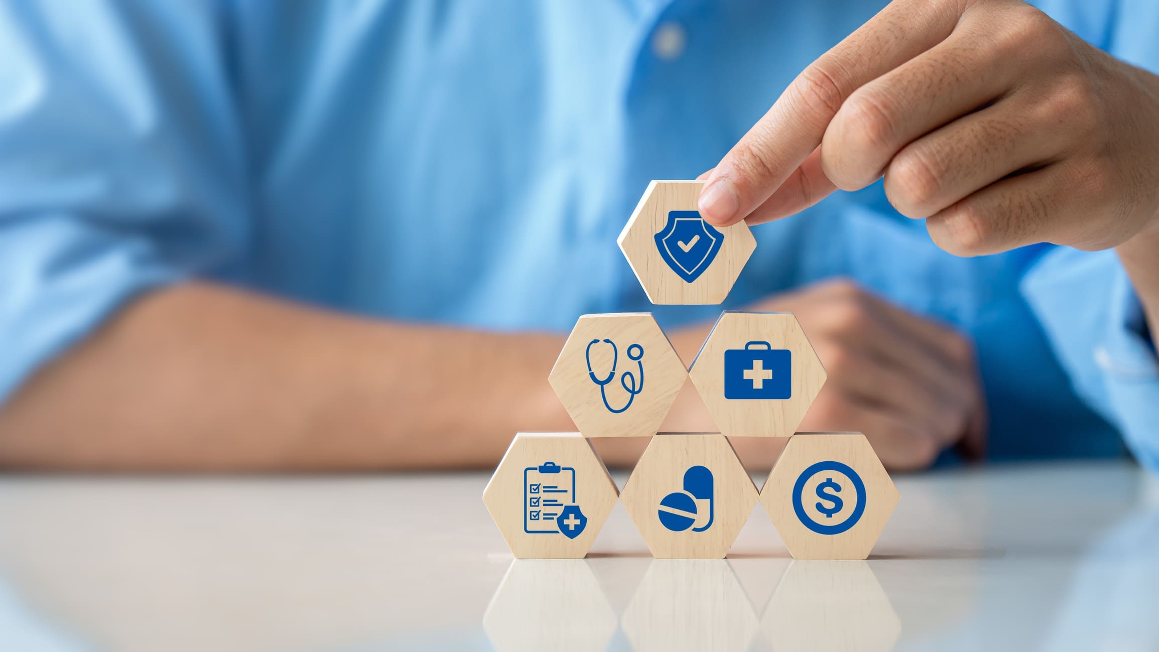 Health insurance concept. Hand holding wooden cube with healthcare medical icon. Family life insurance and policy concepts, hospital, medical treatment. copy space.