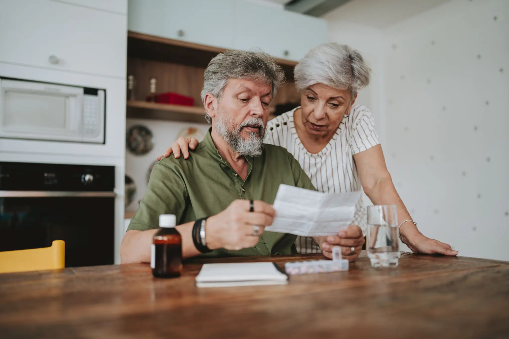 Couple reviewing paperwork at kitchen table
