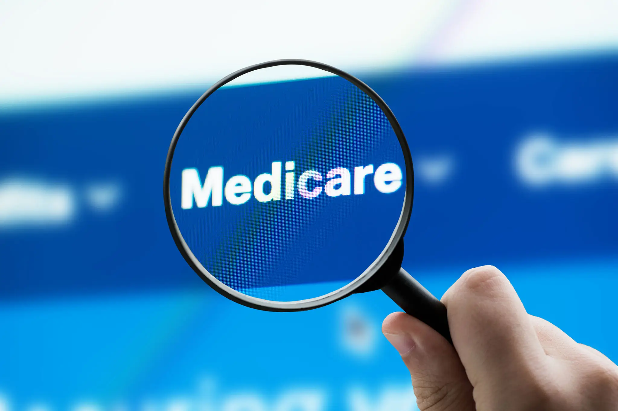 Magnifying glass highlighting Medicare on screen