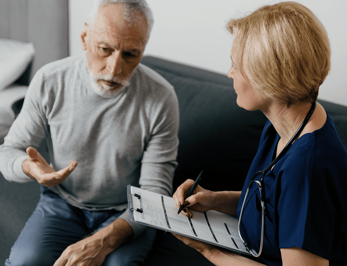 Doctor consulting with elderly patient at home.