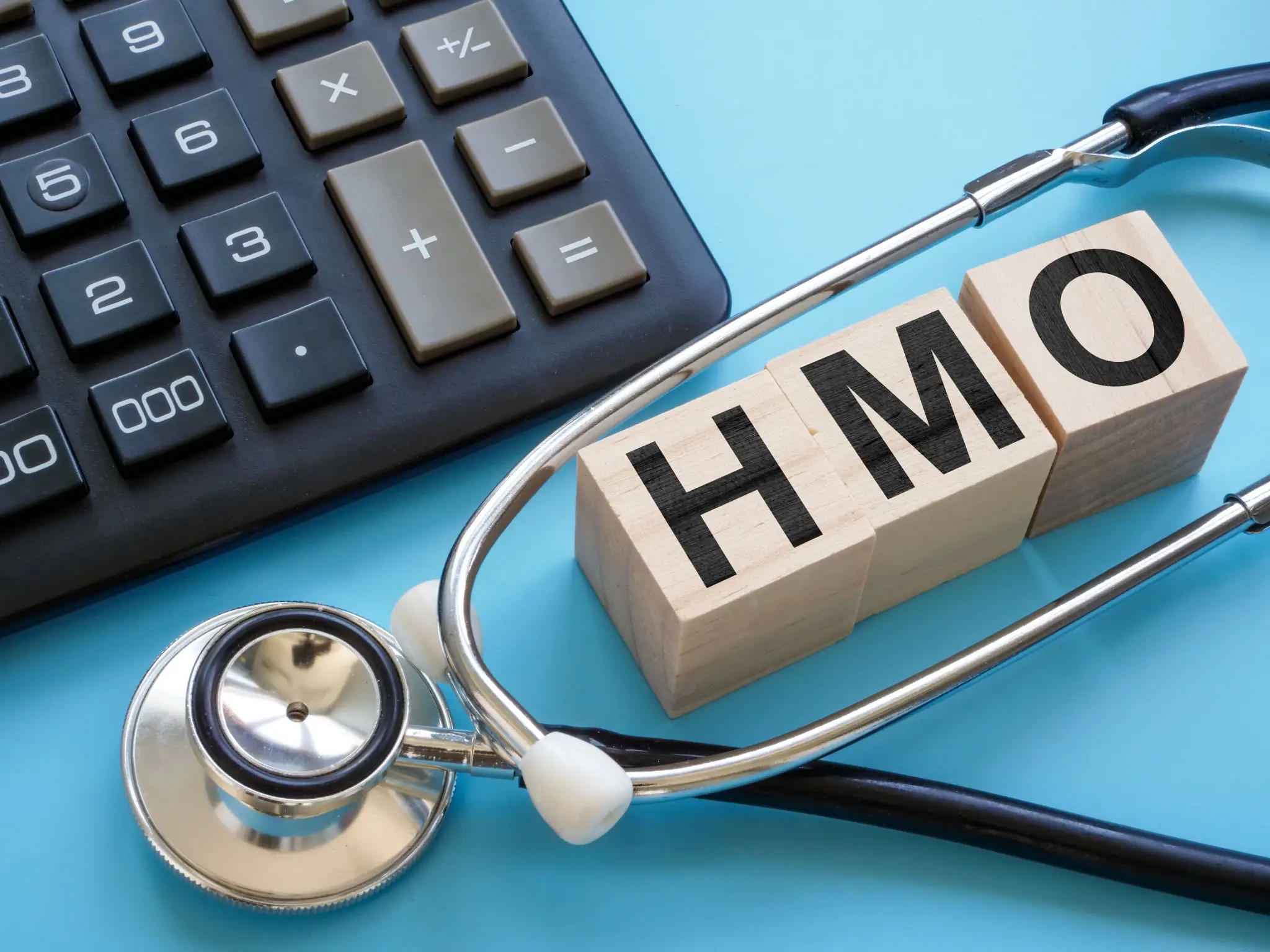 HMO blocks with stethoscope and calculator