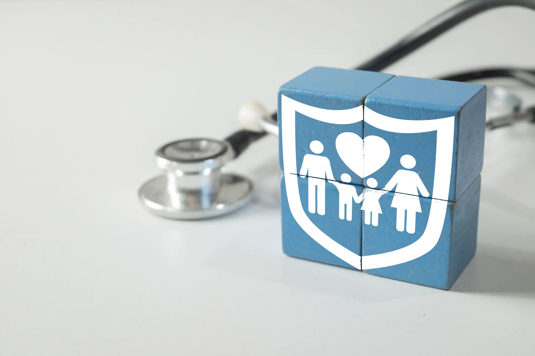 Family health insurance shield with stethoscope