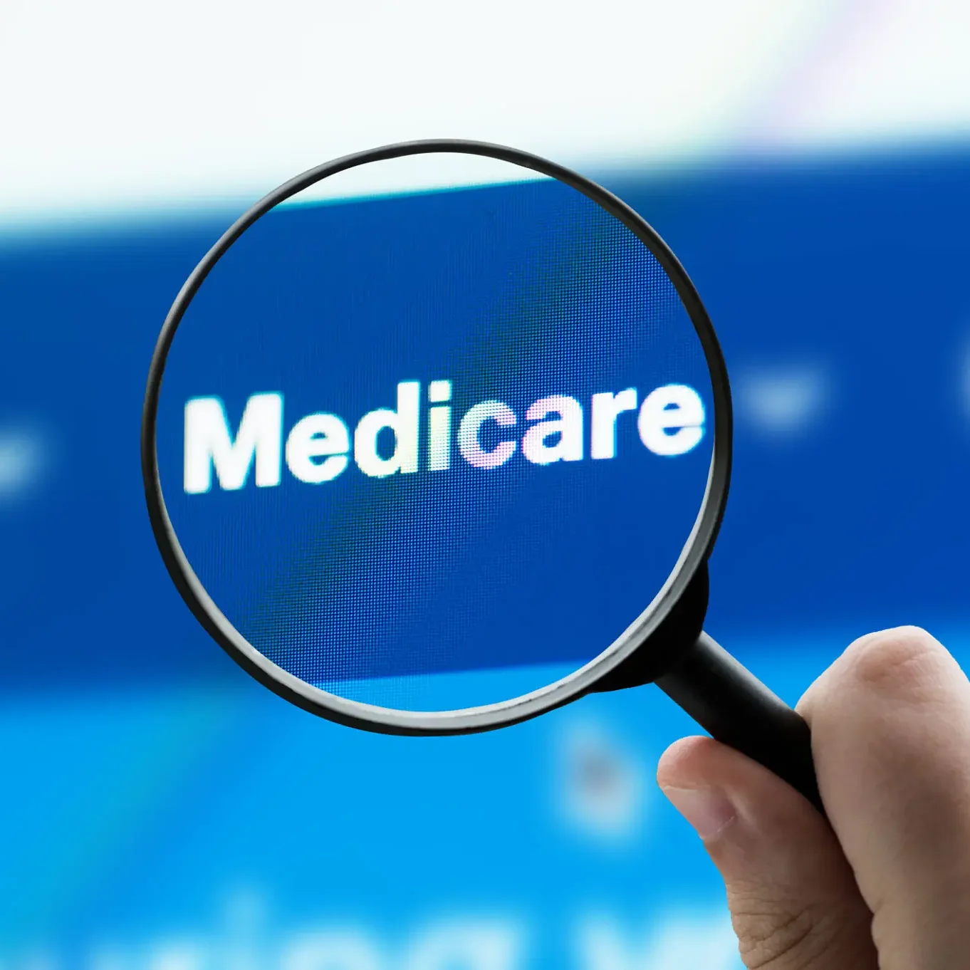 Magnifying glass highlighting Medicare on screen