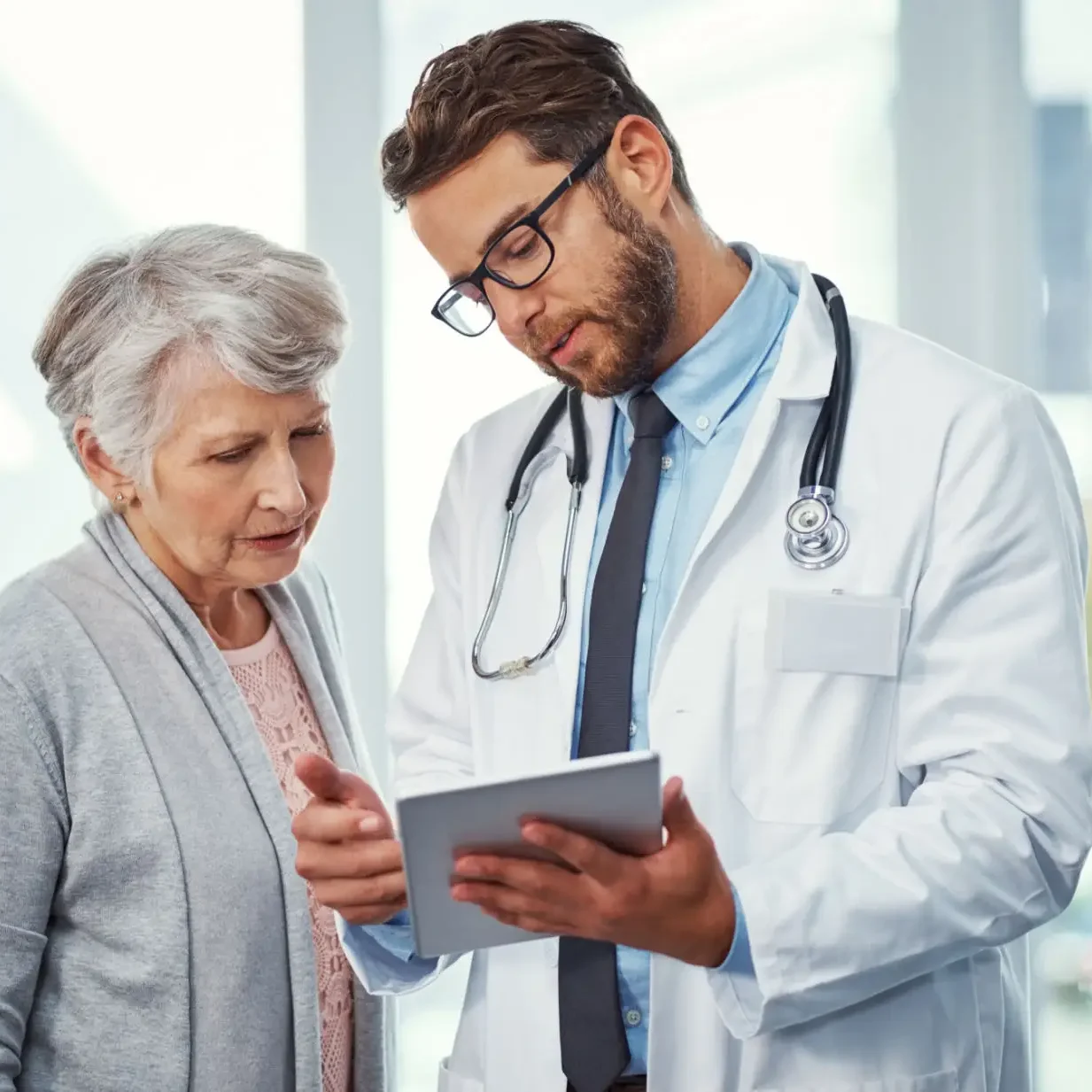 Doctor showing tablet to senior patient